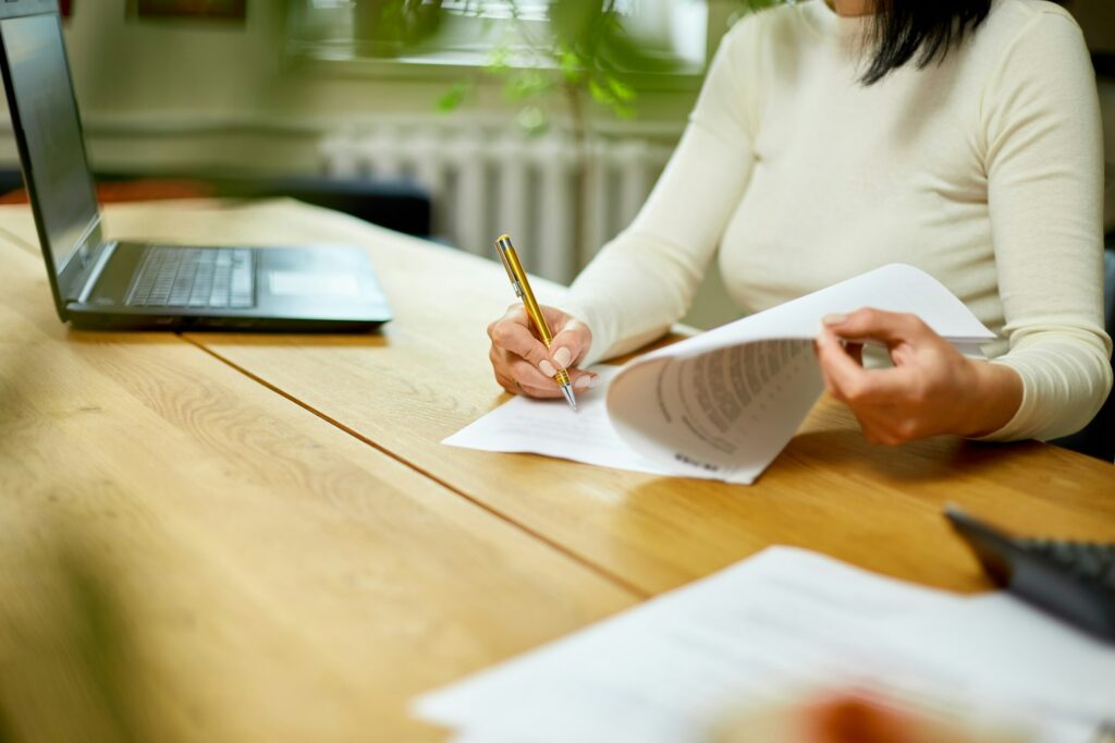 Woman hand signing a contract, making a deal with business partner.